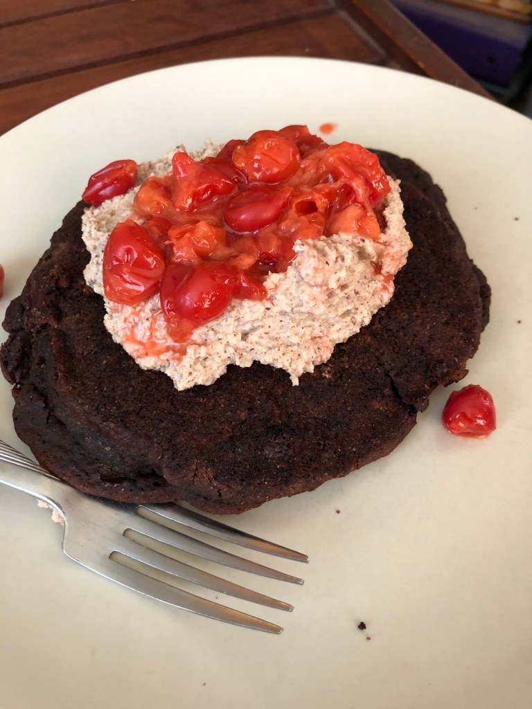 brownie pancake on a plate with hazelnut cream and cherries