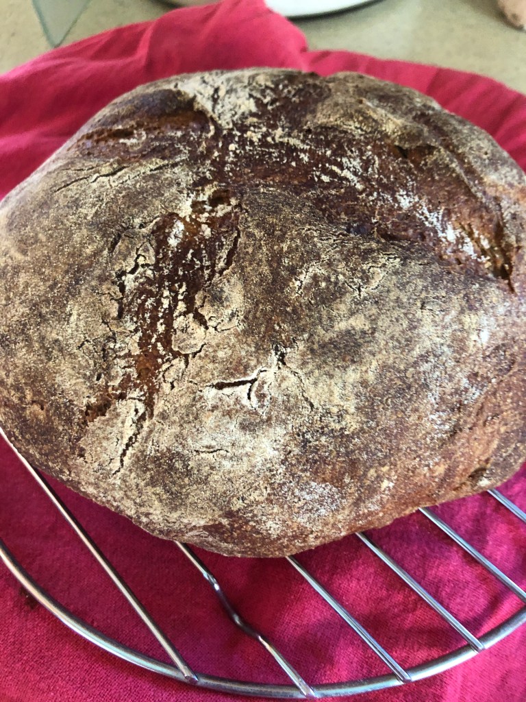 loaf os sourdough bread on a cooling rack