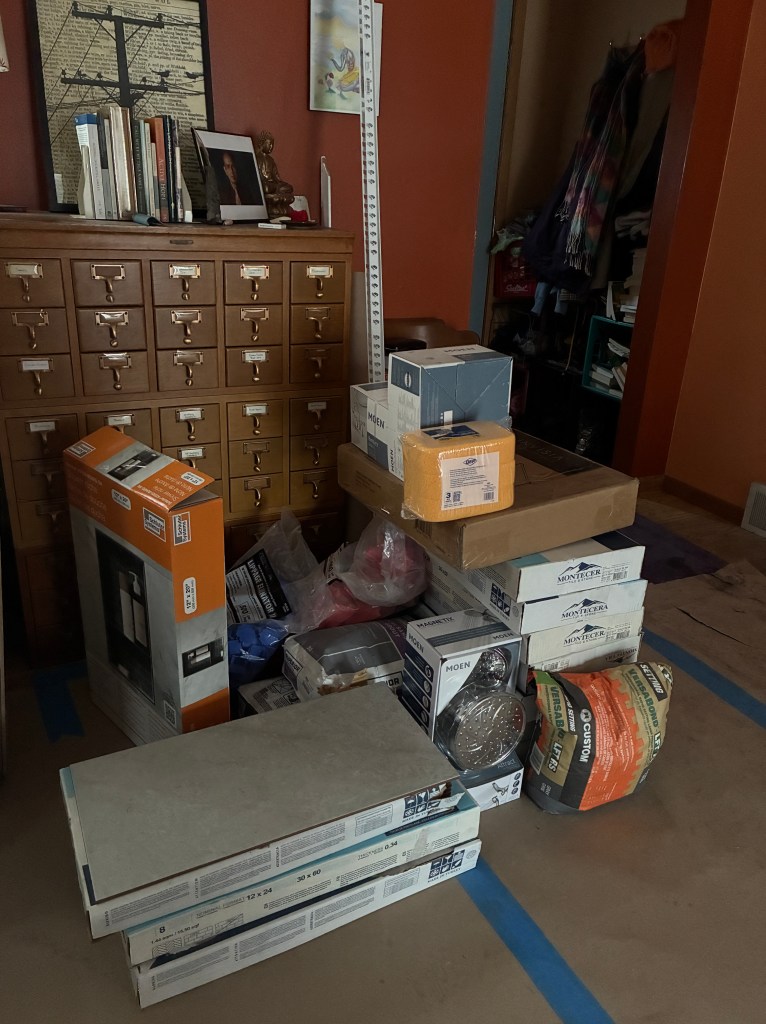 part of living room with boxes of tile and other supplies for bathroom remodel